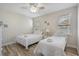 Bright bedroom features two twin beds, white linens, wood-look flooring, natural light from windows, and neutral paint at 1613 Havens Dr., North Myrtle Beach, SC 29582