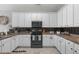 Functional kitchen featuring ample white cabinetry, dark appliances, and countertop space for meal preparation at 1617 N Dogwood Dr. N, Surfside Beach, SC 29575