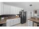 Kitchen with white cabinets, dark appliances, and a view into other areas of the home at 1617 N Dogwood Dr. N, Surfside Beach, SC 29575