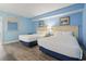 Bright bedroom featuring two beds, light blue walls and laminate flooring at 1708 N Ocean Blvd. # 101, Myrtle Beach, SC 29577