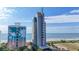 Coastal condo building featuring colorful design, landscaping, and ocean views on sunny day at 1708 N Ocean Blvd. # 101, Myrtle Beach, SC 29577