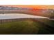 Overlooking a lush green backyard and pond with a vibrant sunset; trampoline on the right at 1709 Perthshire Loop, Myrtle Beach, SC 29579
