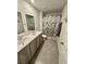 Bathroom features double sink vanity, tile flooring and a shower with modern fixtures and stylish curtain at 1709 Perthshire Loop, Myrtle Beach, SC 29579