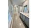 Bathroom featuring gray cabinets with double sinks, walk-in shower with glass door, and neutral tile flooring at 1709 Perthshire Loop, Myrtle Beach, SC 29579