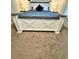 Comfortable bedroom featuring stylish white paneled bed frame, blue bedding, and coordinating nightstands with lamps at 1709 Perthshire Loop, Myrtle Beach, SC 29579
