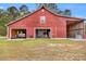 Functional red barn with multiple bays, offering ample storage for equipment and vehicles, open garage doors at 1961 Bright Rd., Little River, SC 29566