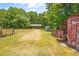 Large manicured yard and rustic outbuildings including a barn with a covered shelter and bench at 1961 Bright Rd., Little River, SC 29566