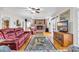Bright living room featuring a brick fireplace, ceiling fan and hardwood flooring at 1961 Bright Rd., Little River, SC 29566