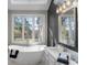 Bright bathroom featuring a freestanding tub, double vanity, and large windows with outdoor views at 1969 Governors Landing Rd. # 224, Murrells Inlet, SC 29576