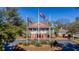 Exterior shot of a grand building with flags, manicured lawns, and a circular driveway at 1969 Governors Landing Rd. # 224, Murrells Inlet, SC 29576