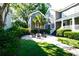 Cozy backyard featuring a fire pit, gravel patio, lush greenery, and comfortable seating at 203 Broad St., Georgetown, SC 29440