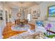 A beautiful dining room featuring a round table, wicker chairs, hardwood floors, and eye-catching blue leaf patterned wallpaper at 203 Broad St., Georgetown, SC 29440