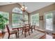 Bright dining room with hardwood floors, large windows, and elegant chandelier at 24 Willowbend Dr., Murrells Inlet, SC 29576