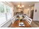 Elegant dining area filled with natural light, a wood table, and a view to the kitchen bar with stainless appliances at 2588 Long Avenue Ext., Conway, SC 29526