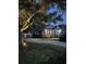 Beautifully lit home at dusk featuring a rocking chair front porch, manicured landscaping, and a winding driveway at 2588 Long Avenue Ext., Conway, SC 29526