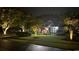 Stunning home exterior at night, enhanced by landscape lighting and lush, green lawn along a quiet street at 2588 Long Avenue Ext., Conway, SC 29526