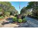 Hunters Ridge entrance sign is surrounded by trees and flowering bushes with the American flag at 2595 Buck Scrape Rd., Myrtle Beach, SC 29588