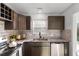 Renovated kitchen featuring dark cabinetry, stainless steel appliances, and elegant marble backsplash at 2595 Buck Scrape Rd., Myrtle Beach, SC 29588