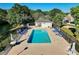 An aerial view of a pool with lounge chairs and tables surrounded by trees with a nearby lake at 2595 Buck Scrape Rd., Myrtle Beach, SC 29588