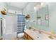 Well-lit bathroom featuring a single sink vanity, tub with shower and blue striped shower curtain at 2636 Brick Dr., Longs, SC 29568