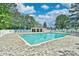 Community pool with clubhouse, lounge chairs, umbrellas, and mature trees at 2636 Brick Dr., Longs, SC 29568