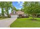 Traditional brick home with manicured lawn, mature trees, and a circular driveway at 2636 Brick Dr., Longs, SC 29568