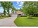 Traditional brick home with manicured lawn, mature trees, and a circular driveway at 2636 Brick Dr., Longs, SC 29568