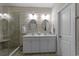 Modern bathroom with double sinks, oval mirrors, and a glass-enclosed shower with bench at 281 Lumbee Circle, Pawleys Island, SC 29585