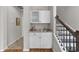 Elegant wet bar featuring granite countertop, storage, and staircase access at 281 Lumbee Circle, Pawleys Island, SC 29585