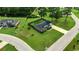 An aerial view of a brick home on a large lot, surrounded by lush greenery and neighborhood streets at 301 Farmtrac Dr., Aynor, SC 29544