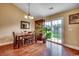 Open dining room with hardwood floors, slider to the backyard, and decorative chandelier at 301 Farmtrac Dr., Aynor, SC 29544