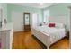 Light bedroom featuring wood floors, a bed, and an antique coat rack with a mirror at 3926 Flagg St., Murrells Inlet, SC 29576