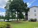 Building exterior view with large trees and a glimpse of the lake nearby on a bright and sunny day at 398 Blue Stem Dr. # 59E, Pawleys Island, SC 29585