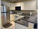 Bright kitchen with stainless steel appliances, white cabinets, granite counters, and tiled floors at 398 Blue Stem Dr. # 59E, Pawleys Island, SC 29585