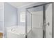 Bright bathroom features a white tiled bathtub and a glass-enclosed shower with chrome fixtures at 400 Hillside Dr. S, North Myrtle Beach, SC 29582