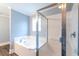 Bright bathroom features a white tiled bathtub and a glass-enclosed shower with chrome fixtures at 400 Hillside Dr. S, North Myrtle Beach, SC 29582