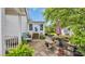 A brick patio with outdoor furniture and foliage with backyard views on a sunny day at 412 Carolina Dr., Loris, SC 29569