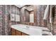 Bathroom features a single sink vanity, bright white countertop, decorative wallpaper, and a mirror at 412 Carolina Dr., Loris, SC 29569