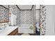Bathroom showcasing a soaking tub, floral wallpaper, and a stylish sink and mirror at 412 Carolina Dr., Loris, SC 29569