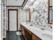 Bathroom features a double sink vanity, mirrors, overhead lighting, and patterned wallpaper at 412 Carolina Dr., Loris, SC 29569