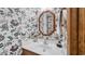 Small bathroom with a octagon mirror above the white sink, with floral wallpaper surrounding at 412 Carolina Dr., Loris, SC 29569