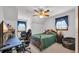 Bedroom features a bed with green comforter, desk, chair, ceiling fan and natural light from two windows at 412 Carolina Dr., Loris, SC 29569