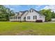 Exterior view of a home with a long front porch, white siding, black shutters, a large yard and green trees at 412 Carolina Dr., Loris, SC 29569