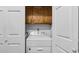 Bright laundry room featuring a white washing machine and dryer, cabinets above, and closet with bifold doors at 412 Carolina Dr., Loris, SC 29569