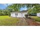 Outbuilding on a grassy lot, with two garage doors, white siding, and green trees in the background at 412 Carolina Dr., Loris, SC 29569