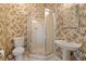 Bathroom with floral wallpaper, glass shower, pedestal sink, and toilet at 435 Ocean Creek Dr. # 2722, Myrtle Beach, SC 29572