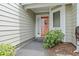 Inviting front entrance with a red door, complemented by lush greenery and natural light at 435 Ocean Creek Dr. # 2722, Myrtle Beach, SC 29572