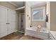 Well-lit bathroom features a shower and soaking tub with a window at 455 Hyacinth Loop, Murrells Inlet, SC 29576