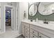 Bathroom featuring double vanity, mirrors, storage, and walk-in closet access at 4927 Sandlewood Dr., Myrtle Beach, SC 29579