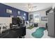 Bedroom featuring a dark blue accent wall, neutral carpet, a comfortable gray sofa, and a ceiling fan at 4927 Sandlewood Dr., Myrtle Beach, SC 29579